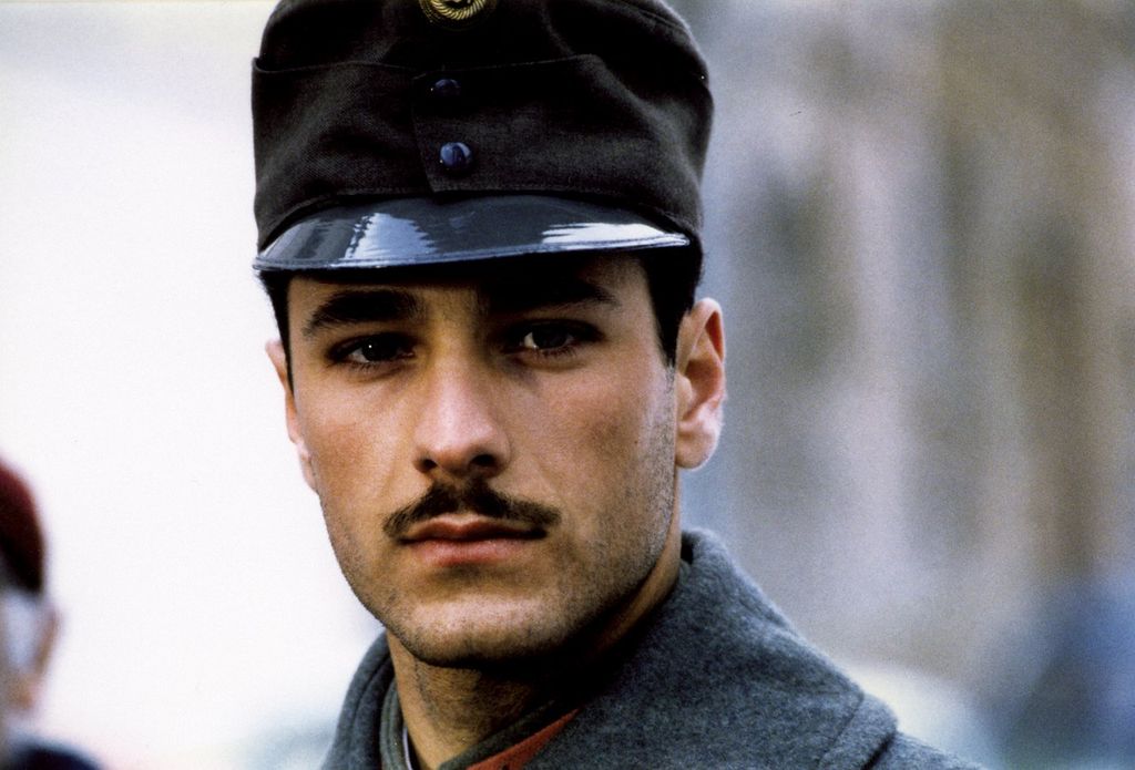 Una foto del film \&quot;Border\&quot;, che rappresenta un giovane vestito con un\&#039;uniforme militare, con capelli neri e baffi.